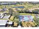 Aerial shot featuring pickleball courts, bocce ball, green spaces, and nearby condos in a vibrant community setting at 803 Carnoustie Dr, Venice, FL 34293