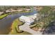 Expansive waterfront property featuring a well-maintained home with a paved driveway and lush landscaping at 803 Carnoustie Dr, Venice, FL 34293