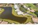 Aerial view of home near a golf course and a pond in a residential community at 803 Carnoustie Dr, Venice, FL 34293
