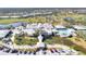 Aerial view of a golf and country club with pool, and lush landscaping and a large parking area at 803 Carnoustie Dr, Venice, FL 34293