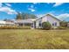 Back exterior of home with large yard overlooking water and screened in patio at 803 Carnoustie Dr, Venice, FL 34293