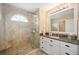 Elegant bathroom features a tiled walk-in shower, granite countertop, and white cabinetry at 803 Carnoustie Dr, Venice, FL 34293