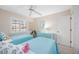 Bright bedroom with twin beds with blue bedding, ceiling fan, window with shutters and decor at 803 Carnoustie Dr, Venice, FL 34293