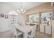 Elegant dining room with a white table, modern chandelier, and built-in mirrored display cabinets at 803 Carnoustie Dr, Venice, FL 34293