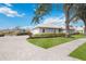 Well-maintained driveway and landscaping surrounding a single-story home with neutral color palette at 803 Carnoustie Dr, Venice, FL 34293