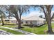 Beautifully maintained single-story home with mature trees, lush lawn, and manicured shrubbery at 803 Carnoustie Dr, Venice, FL 34293