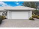 Attached two-car garage with a clean white door and a paved driveway, showcasing curb appeal at 803 Carnoustie Dr, Venice, FL 34293