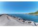 Picturesque view of a stone jetty extending into the clear blue water, creating a scenic coastal landscape at 803 Carnoustie Dr, Venice, FL 34293