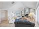 Open living room features vaulted ceilings, a stylish fireplace, comfortable seating, and bright natural light at 803 Carnoustie Dr, Venice, FL 34293