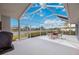 Spacious screened-in patio with dining set, offering views of the lake and community at 803 Carnoustie Dr, Venice, FL 34293