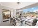 Covered patio with dining table and seating overlooking the backyard and water view at 803 Carnoustie Dr, Venice, FL 34293