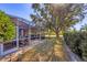 Expansive backyard featuring a screened lanai, lush landscaping, and mature trees, creating a private and serene outdoor space at 805 Derbyshire Dr, Venice, FL 34285