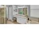 Well-lit bathroom vanity, granite counters, soaking tub, shower and modern fixtures at 805 Derbyshire Dr, Venice, FL 34285