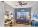 Charming bedroom featuring hardwood floors, ceiling fan, and a daybed under a window with blue floral curtains at 805 Derbyshire Dr, Venice, FL 34285