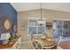 Charming dining area with round wood table, stylish chairs, and sliding door access to the screened lanai at 805 Derbyshire Dr, Venice, FL 34285