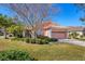 A well-maintained single-story home with verdant landscaping and a pink two car garage door at 805 Derbyshire Dr, Venice, FL 34285