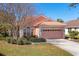 Charming home with meticulous landscaping, a tile roof and a pink two car garage at 805 Derbyshire Dr, Venice, FL 34285