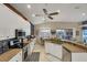 Bright kitchen with white cabinets, granite countertops, stainless steel appliances, and an adjacent dining area at 805 Derbyshire Dr, Venice, FL 34285