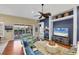 Comfortable living room featuring hardwood floors, a large TV, and access to the outdoor screened lanai at 805 Derbyshire Dr, Venice, FL 34285