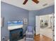 Comfortable office space with blue accent wall, television, chair, and an open view to dining area at 805 Derbyshire Dr, Venice, FL 34285