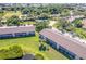 Aerial view of well-maintained condo buildings with a pool and lush greenery at 811 Waterside Dr # 102, Venice, FL 34285