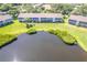 Aerial view of waterfront condominiums with lush landscaping around a scenic pond at 811 Waterside Dr # 102, Venice, FL 34285