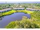 Aerial view of the pond surrounded by lush greenery and well-maintained condo buildings at 811 Waterside Dr # 102, Venice, FL 34285