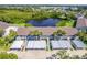 An aerial view of this condo features assigned covered parking and a peaceful pond surrounded by lush landscaping at 811 Waterside Dr # 102, Venice, FL 34285