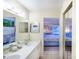 Modern bathroom featuring a double vanity, a large mirror, and a glimpse of the inviting bedroom at 811 Waterside Dr # 102, Venice, FL 34285
