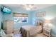 Cozy bedroom with a comfortable twin bed, a wicker dresser, and a sunlit window offering a peaceful retreat at 811 Waterside Dr # 102, Venice, FL 34285