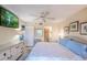Bright bedroom featuring a queen bed, wicker dresser, and a serene view of the en-suite bathroom and closet at 811 Waterside Dr # 102, Venice, FL 34285