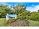 Welcome to Venice sign surrounded by lush greenery and vibrant flowers at 811 Waterside Dr # 102, Venice, FL 34285
