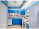 A beautifully remodeled kitchen has blue cabinetry, tile flooring, a dishwasher, and a double basin sink at 811 Waterside Dr # 102, Venice, FL 34285