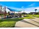 Community playground with modern train-themed equipment, covered picnic tables, and recreational green spaces at 811 Waterside Dr # 102, Venice, FL 34285