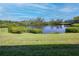 Scenic backyard with a picturesque pond view and lush green lawn at 811 Waterside Dr # 102, Venice, FL 34285