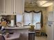Bright kitchen area with window views, vintage wallpaper, and updated appliances at 88 Bainbridge Dr # 88, Nokomis, FL 34275