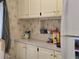 Charming kitchen with vintage wallpaper and upper cabinets at 88 Bainbridge Dr # 88, Nokomis, FL 34275