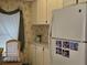 Charming kitchen with white appliances, cabinets, and vintage wallpaper at 88 Bainbridge Dr # 88, Nokomis, FL 34275