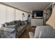 Welcoming living space featuring a patterned sofa, large TV, and lots of light at 88 Bainbridge Dr # 88, Nokomis, FL 34275
