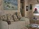 Inviting living area boasts a beach painting and comfortable daybed with pillows at 88 Bainbridge Dr # 88, Nokomis, FL 34275