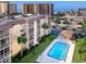 Aerial view of building featuring a pool and manicured lawn at 995 Laguna Drive # 303, Venice, FL 34285