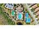 Aerial view of community pool, clubhouse, tennis and bocce ball courts surrounded by lush landscaping and well-maintained grounds at 351 Carlino Dr, Nokomis, FL 34275