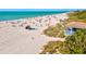 Sandy beach with azure water and a lifeguard station with tropical vegetation, offering a stunning coastal experience at 351 Carlino Dr, Nokomis, FL 34275