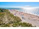 Scenic beach view with sunbathers, gentle waves, and a distant breakwater on a clear sunny day near greenery at 351 Carlino Dr, Nokomis, FL 34275