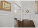 Inviting foyer with dark wood floors, white wainscoting, and decorative artwork at 351 Carlino Dr, Nokomis, FL 34275