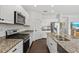 Kitchen with white cabinets, granite countertops, stainless steel appliances, and marble backsplash at 351 Carlino Dr, Nokomis, FL 34275
