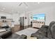 Open-concept living room flows into the kitchen, featuring white walls, a large TV, and hardwood floors at 351 Carlino Dr, Nokomis, FL 34275