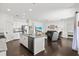 Open kitchen and living area boasts white cabinetry, granite countertops, and comfortable seating at 351 Carlino Dr, Nokomis, FL 34275