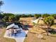 Aerial view of a playground with colorful equipment, picnic tables, and palm trees, near a sandy beach at 351 Carlino Dr, Nokomis, FL 34275