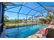 Screened in pool with view of lake and lush trees at 351 Carlino Dr, Nokomis, FL 34275